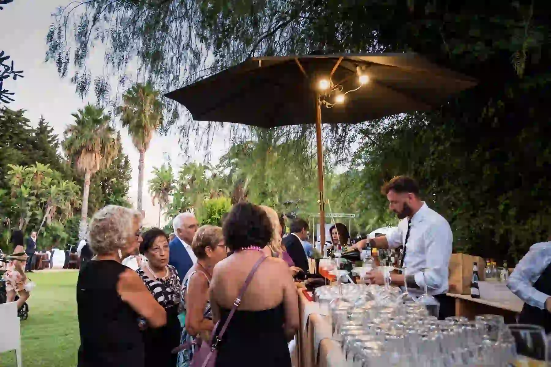 Festa estiva all'aperto con bar e palme nel giardino
